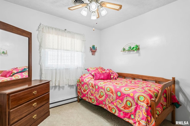 carpeted bedroom with visible vents, baseboard heating, and a ceiling fan