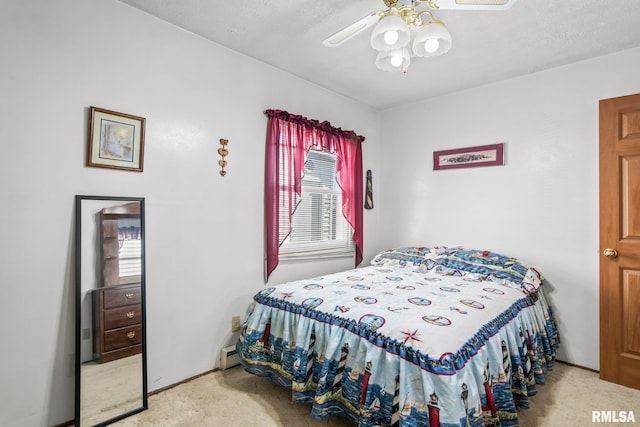 carpeted bedroom featuring a ceiling fan and a baseboard radiator