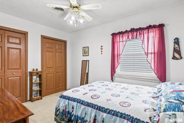 bedroom with a textured ceiling, ceiling fan, and light carpet