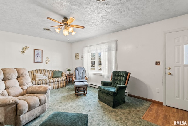 living area with visible vents, a ceiling fan, a baseboard heating unit, a textured ceiling, and baseboards