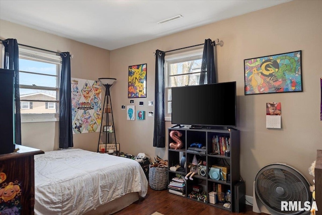 bedroom featuring wood finished floors and visible vents