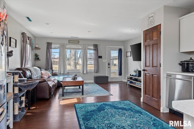 living area with dark wood finished floors, baseboards, and visible vents