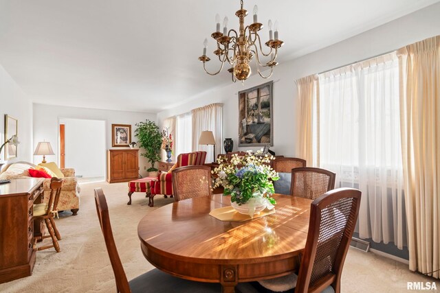 dining room featuring a notable chandelier, light colored carpet, and visible vents