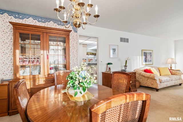 dining area featuring wallpapered walls, a notable chandelier, visible vents, and carpet floors