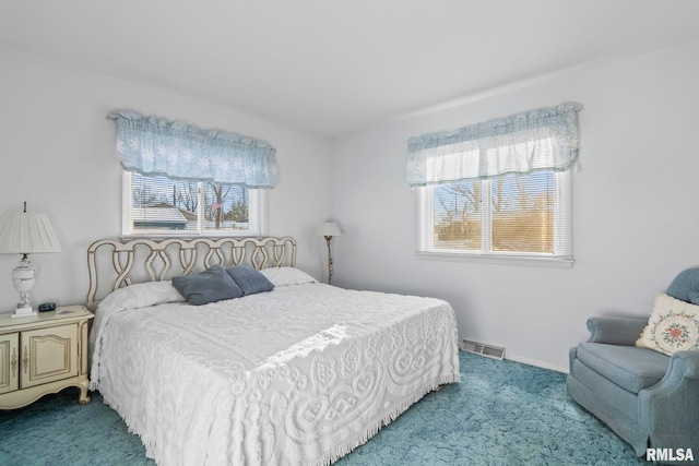 carpeted bedroom with visible vents and baseboards