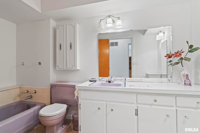 bathroom featuring vanity, toilet, visible vents, and a bathing tub