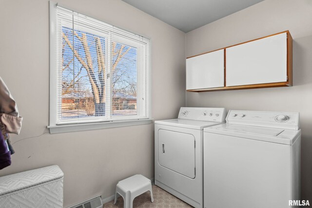 laundry area with visible vents, baseboards, cabinet space, light colored carpet, and washer and clothes dryer