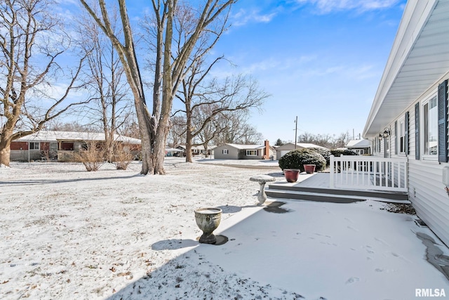 yard layered in snow with a wooden deck