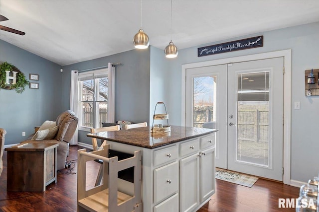 kitchen with pendant lighting, open floor plan, dark wood-style floors, french doors, and white cabinets