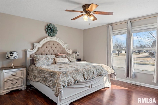 bedroom featuring dark wood-style floors, visible vents, ceiling fan, and baseboards