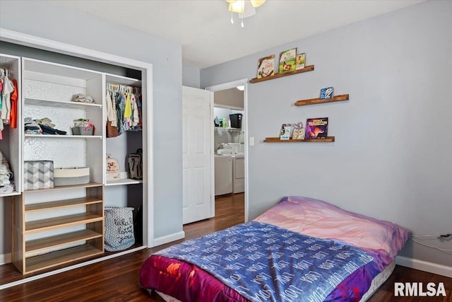 bedroom featuring a closet, baseboards, independent washer and dryer, and wood finished floors