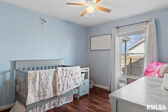 bedroom featuring baseboards, wood finished floors, and a ceiling fan