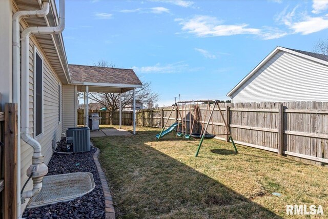 view of yard with a patio, a playground, a fenced backyard, and central air condition unit