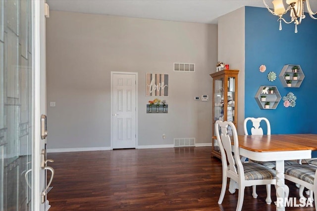 dining area featuring visible vents, baseboards, wood finished floors, and a chandelier