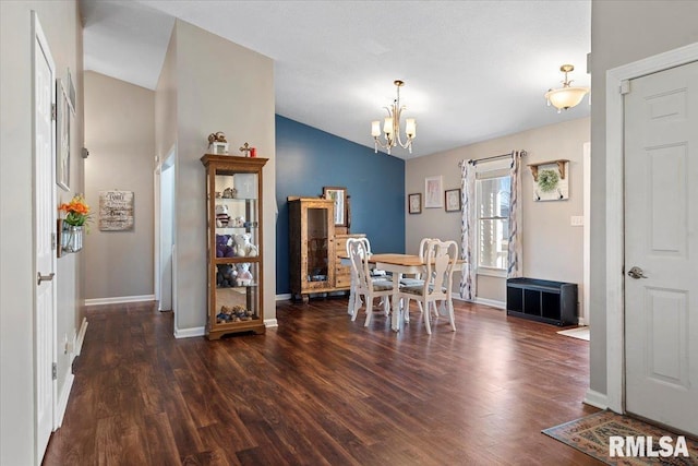 dining area with baseboards, an inviting chandelier, wood finished floors, and vaulted ceiling