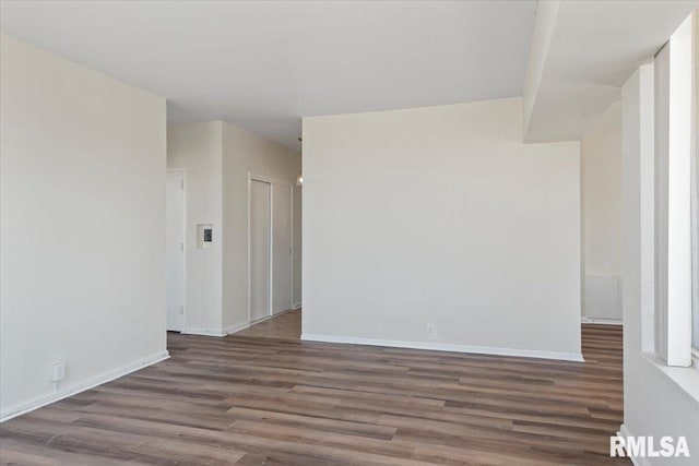 spare room featuring wood finished floors and baseboards