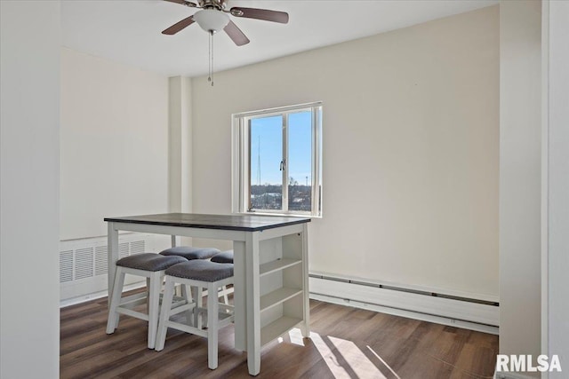 dining room with wood finished floors, visible vents, baseboard heating, and ceiling fan