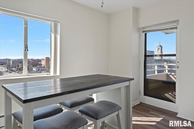 dining area with a view of city and dark wood-style flooring