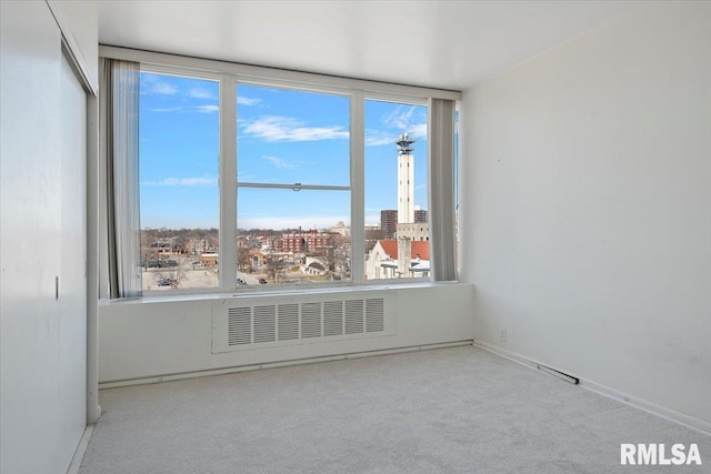 spare room featuring a view of city and carpet flooring