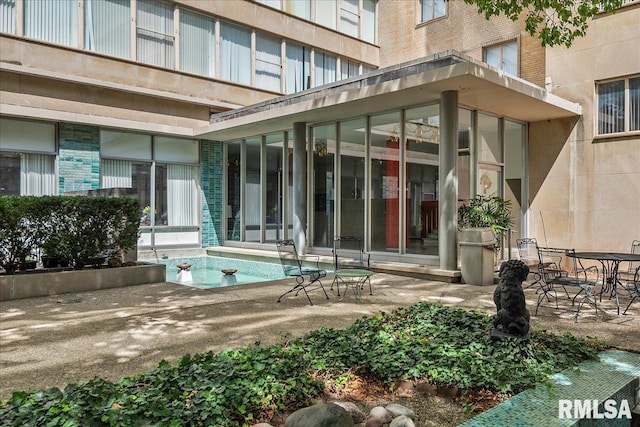 view of exterior entry with a patio area and brick siding