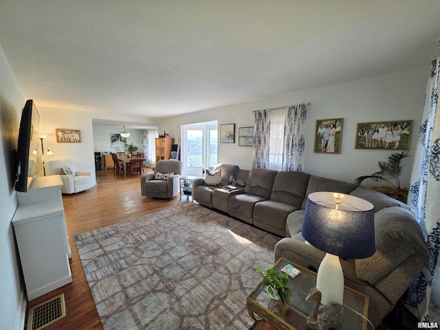 living area with visible vents and wood finished floors