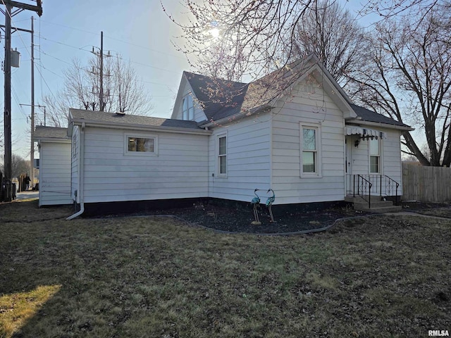 rear view of property with a yard and fence