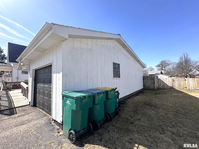 view of property exterior featuring an outbuilding, fence, a garage, and a lawn