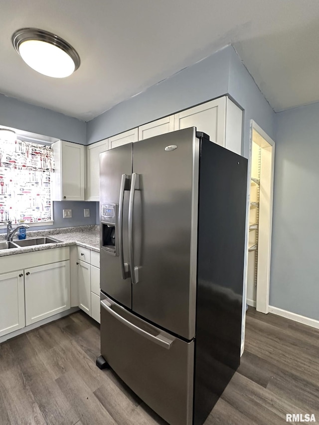 kitchen featuring a sink, white cabinetry, stainless steel fridge with ice dispenser, baseboards, and dark wood-style flooring