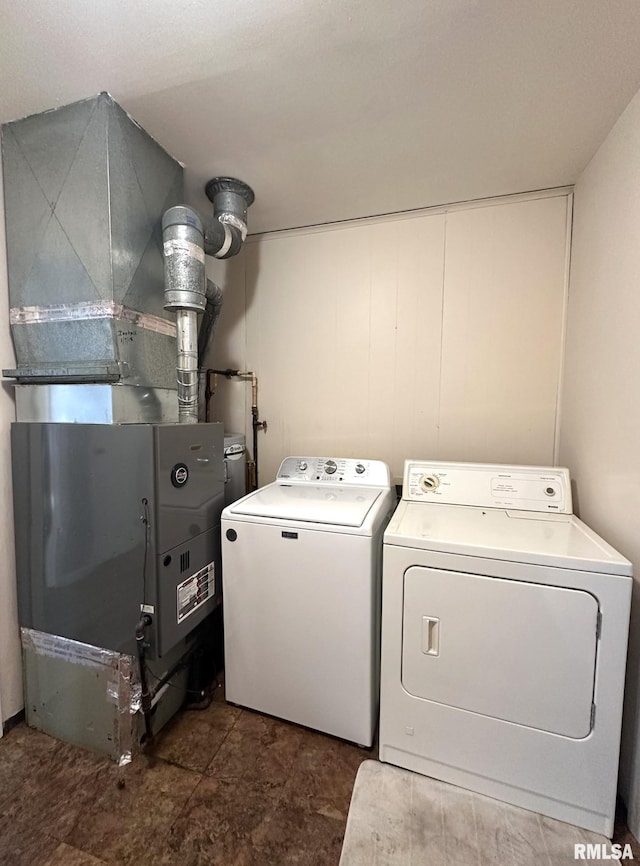 washroom with laundry area, heating unit, and independent washer and dryer