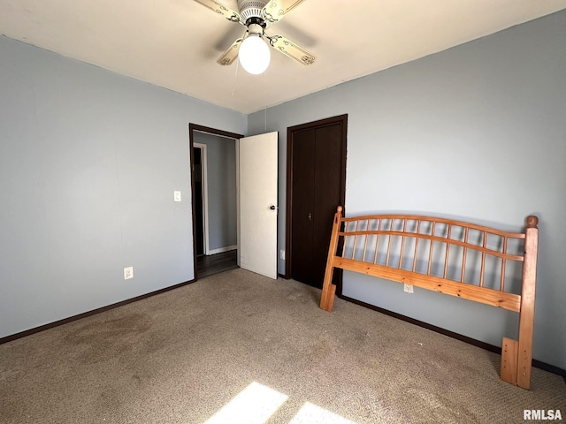 unfurnished bedroom with carpet flooring, a ceiling fan, and baseboards