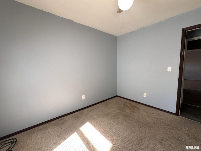 spare room with baseboards and carpet flooring