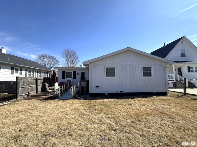 back of property featuring a yard and fence