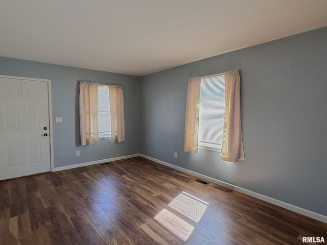 entrance foyer featuring visible vents, baseboards, and wood finished floors