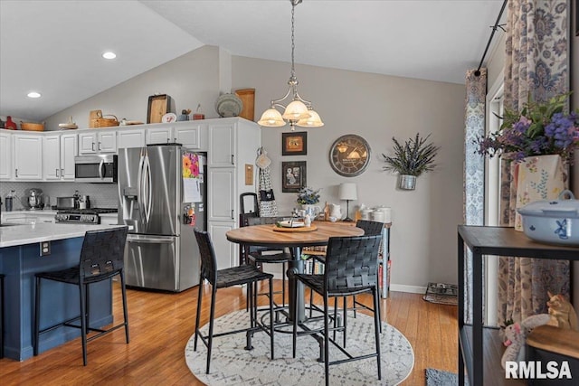 dining area featuring recessed lighting, baseboards, lofted ceiling, and light wood-style floors