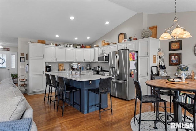 kitchen featuring a sink, appliances with stainless steel finishes, white cabinets, and light countertops