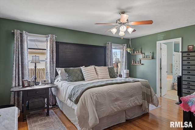 bedroom featuring ensuite bath, ceiling fan, and wood finished floors