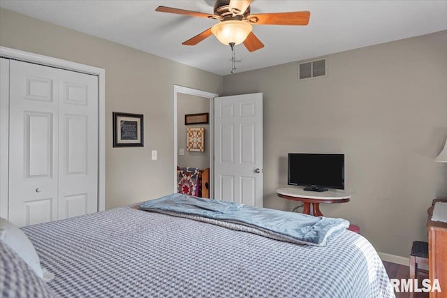 bedroom with wood finished floors, a ceiling fan, visible vents, baseboards, and a closet