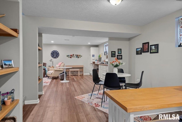 dining area featuring hardwood / wood-style floors, recessed lighting, baseboards, and a textured ceiling