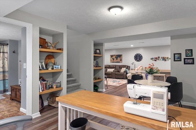 office area featuring built in shelves, dark wood-style floors, baseboards, and a textured ceiling