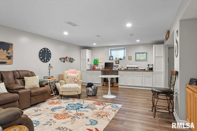 living room with recessed lighting, light wood-style flooring, and visible vents