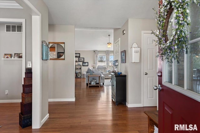 foyer entrance featuring a ceiling fan, wood finished floors, visible vents, and baseboards