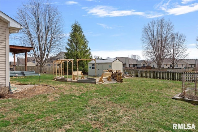 view of yard featuring an outbuilding, a storage unit, and a fenced backyard