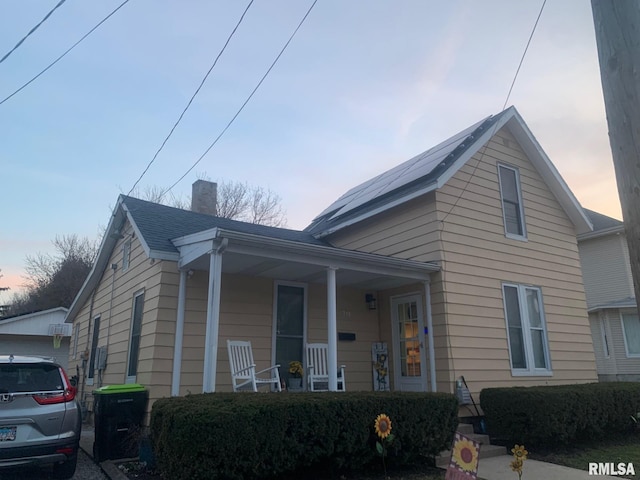 view of front of home with a porch and a chimney