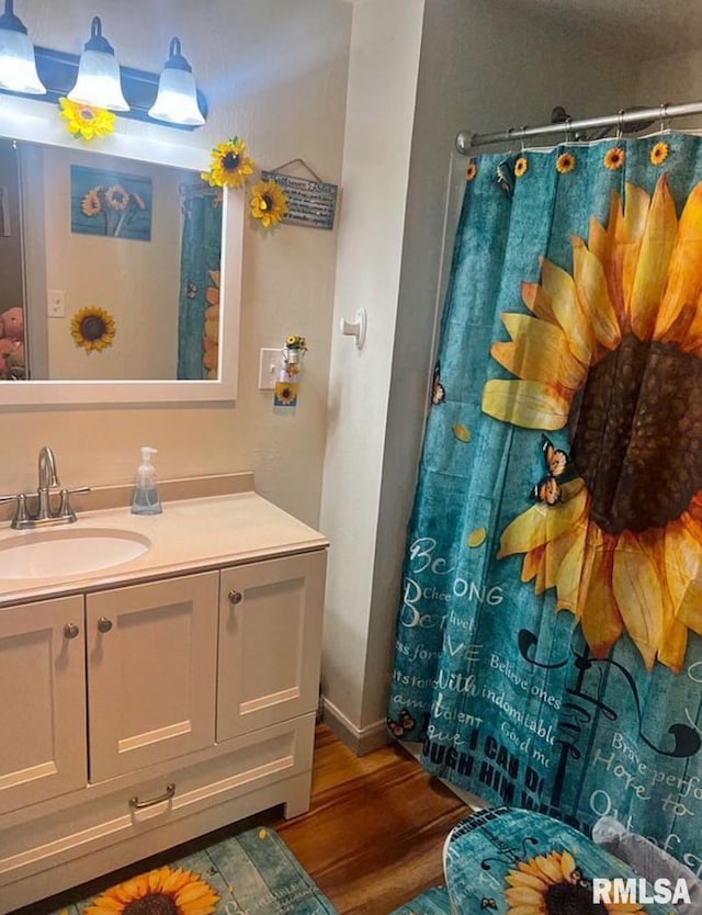 bathroom with vanity, a shower with shower curtain, and wood finished floors