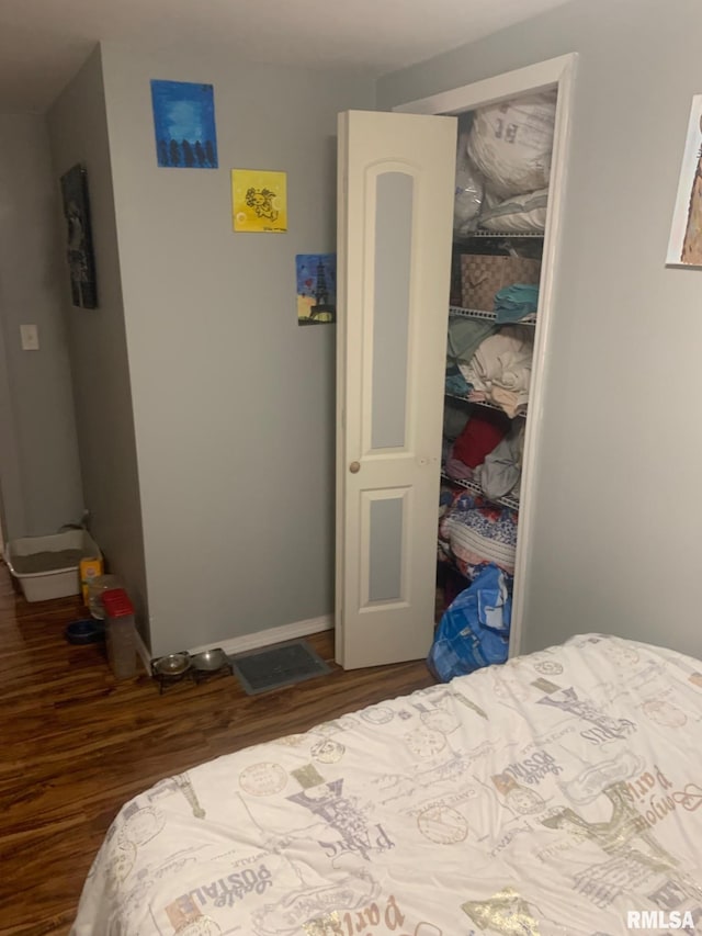 bedroom with a closet, baseboards, and wood finished floors