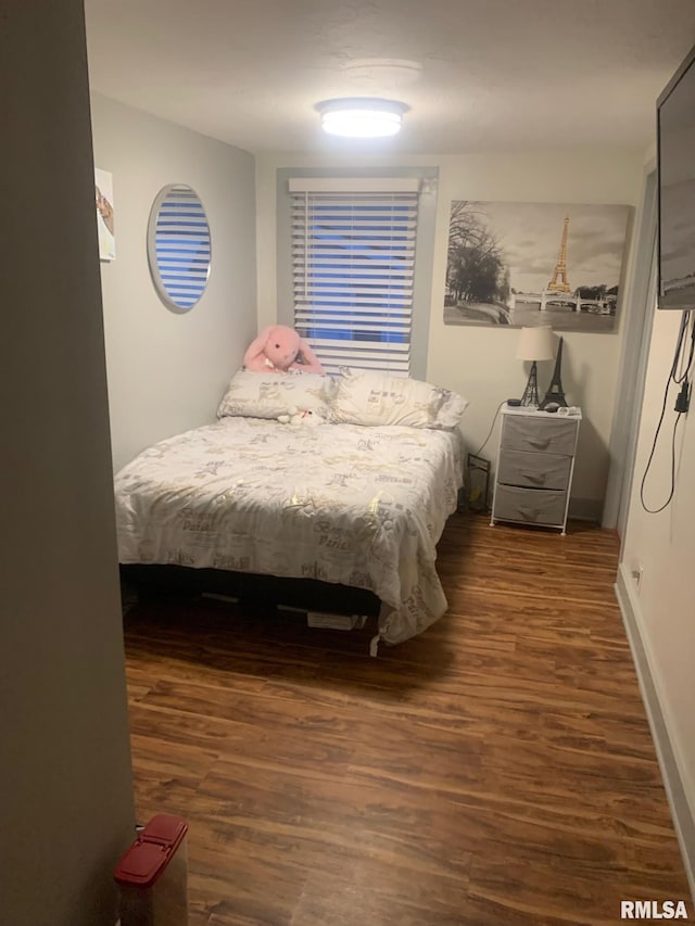 bedroom featuring baseboards and wood finished floors