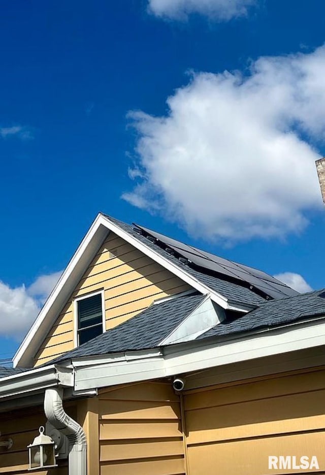 details featuring a downspout, gutters, and a shingled roof