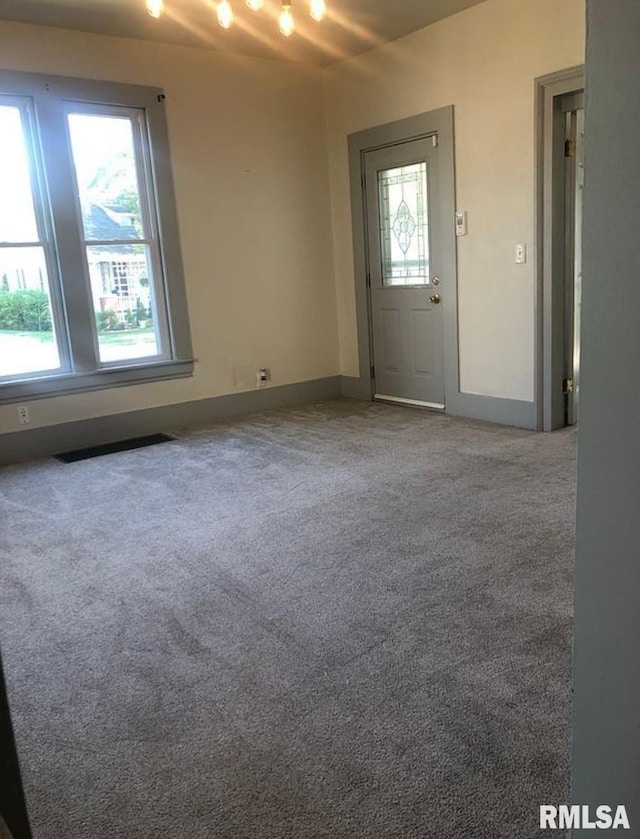 interior space featuring baseboards, visible vents, and carpet floors