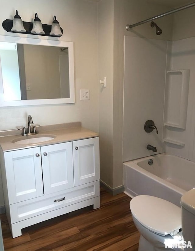 full bath featuring vanity, bathing tub / shower combination, toilet, and wood finished floors