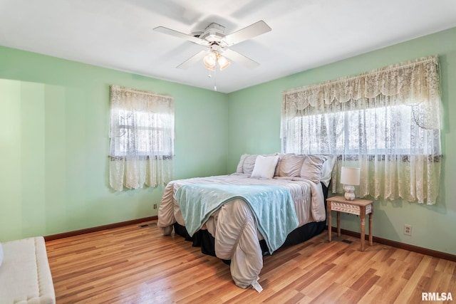 bedroom with ceiling fan, baseboards, and wood finished floors